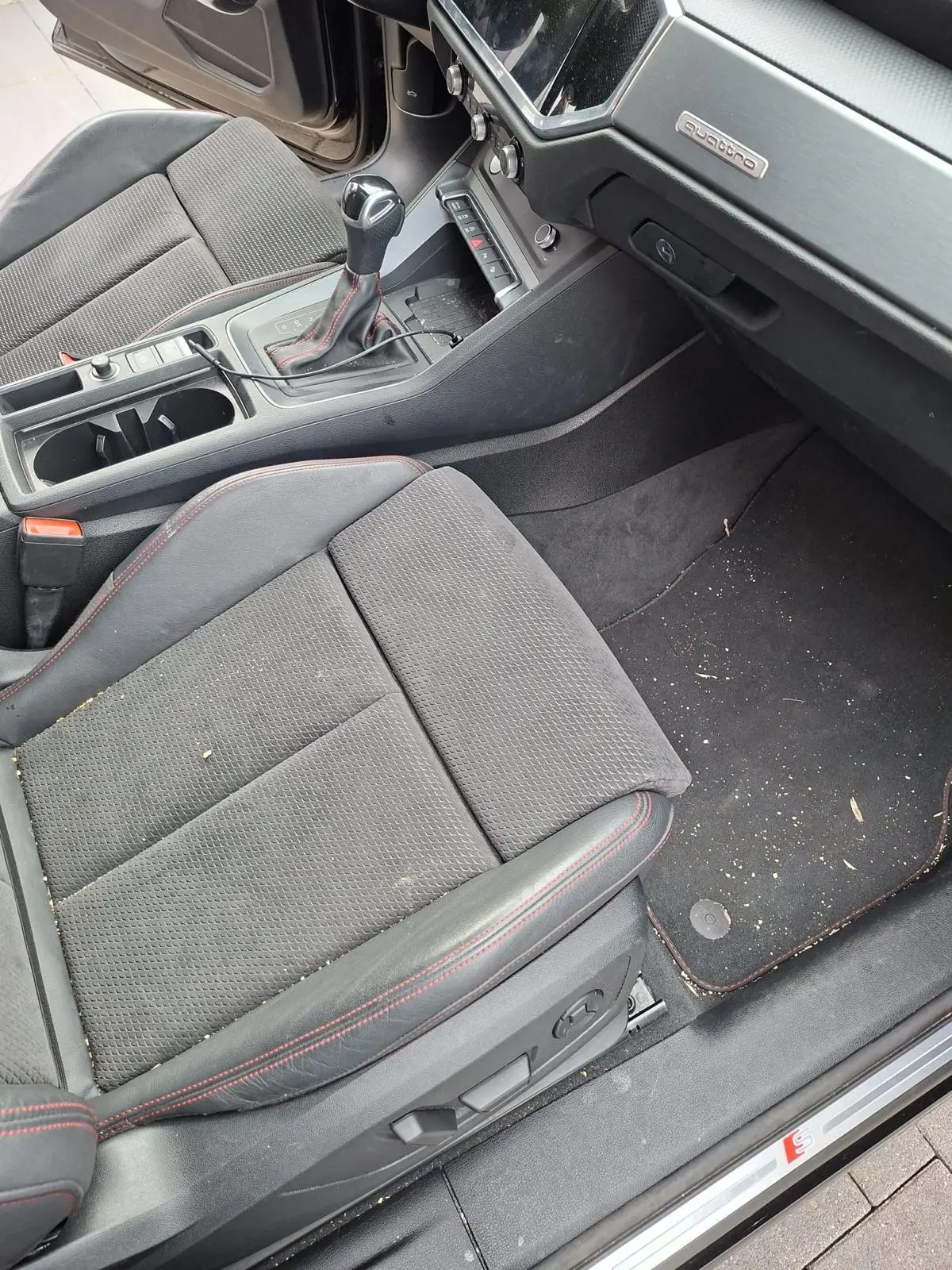 Vervuilde passagiersstoel en mat in een Audi voor reiniging